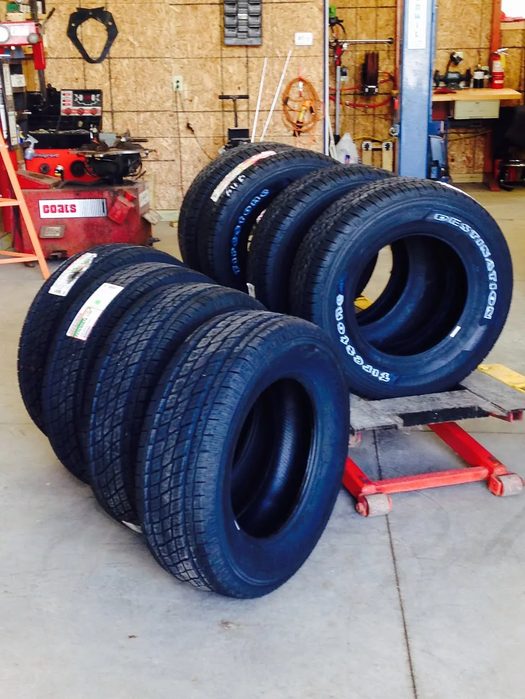 A set of new tires stacked on the shop floor, ready to go on